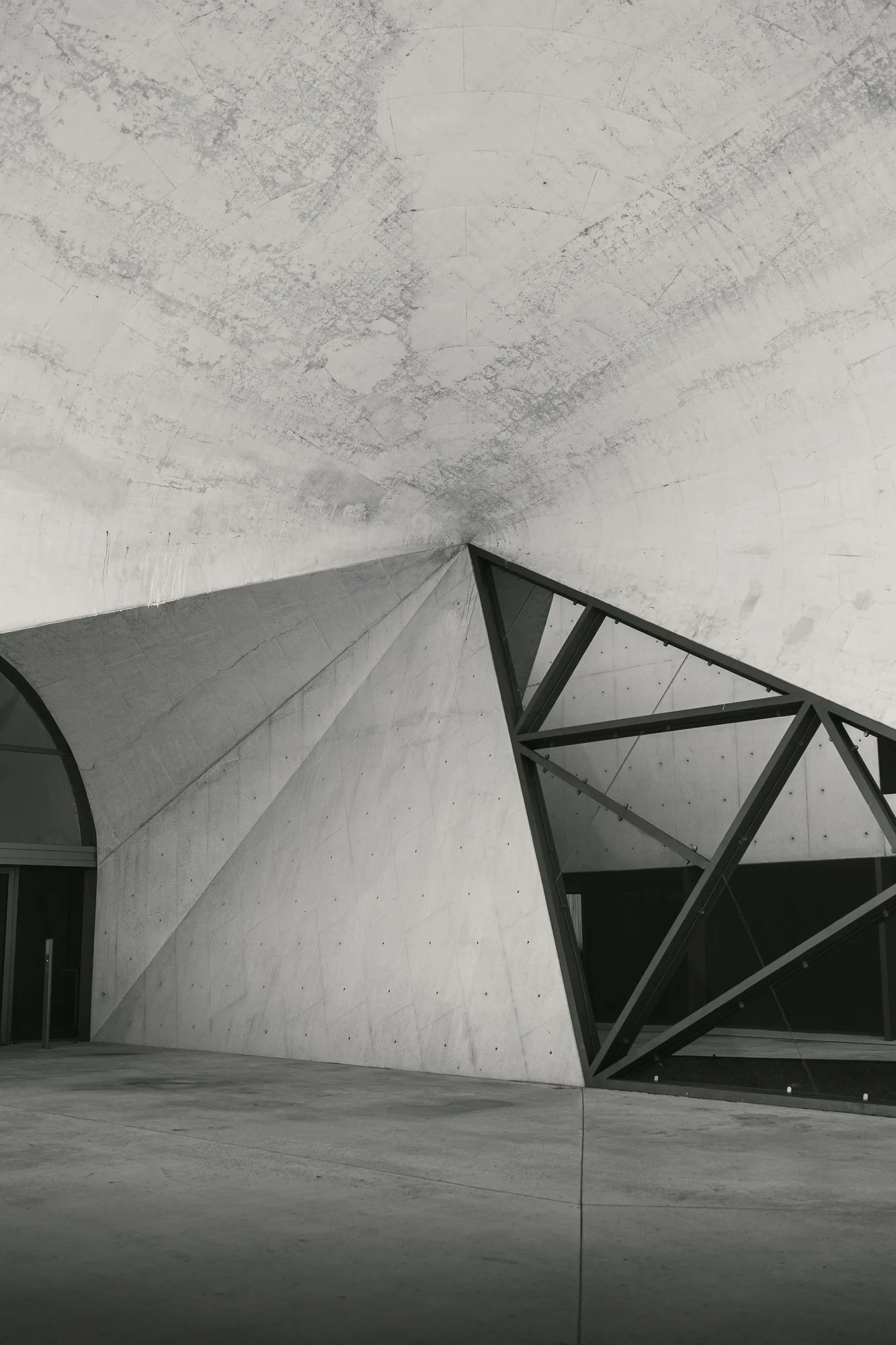 Geometric concrete architecture with angular openings and intersecting lines.
