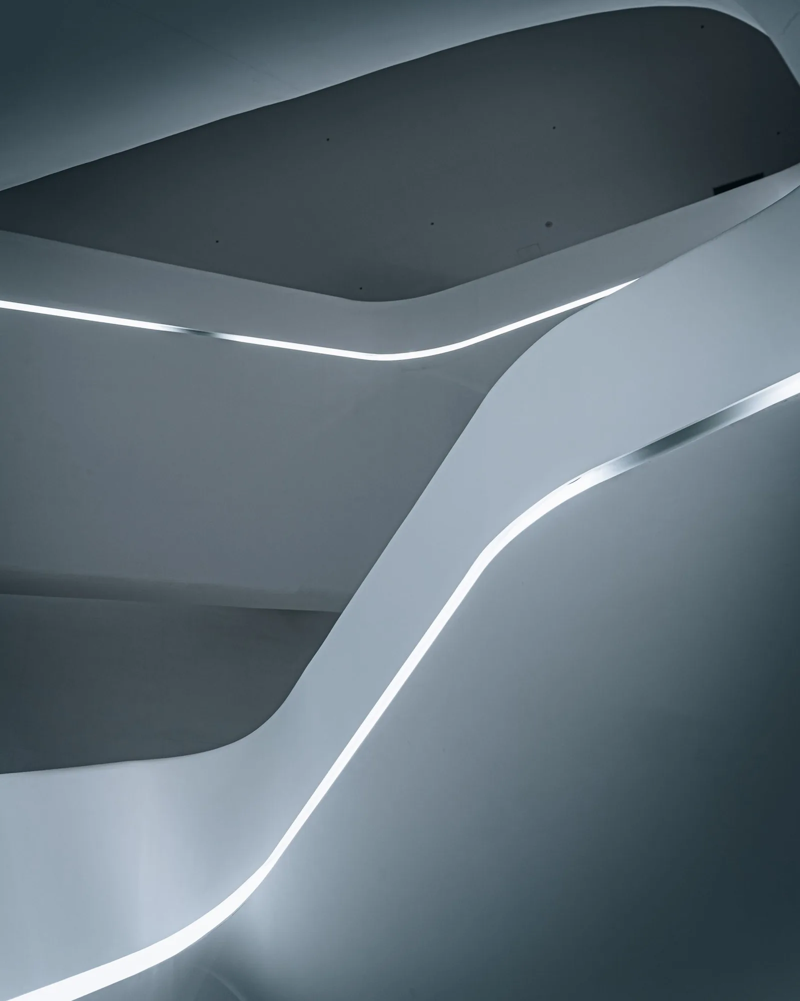 A sculptural modern staircase with sweeping curved edges.