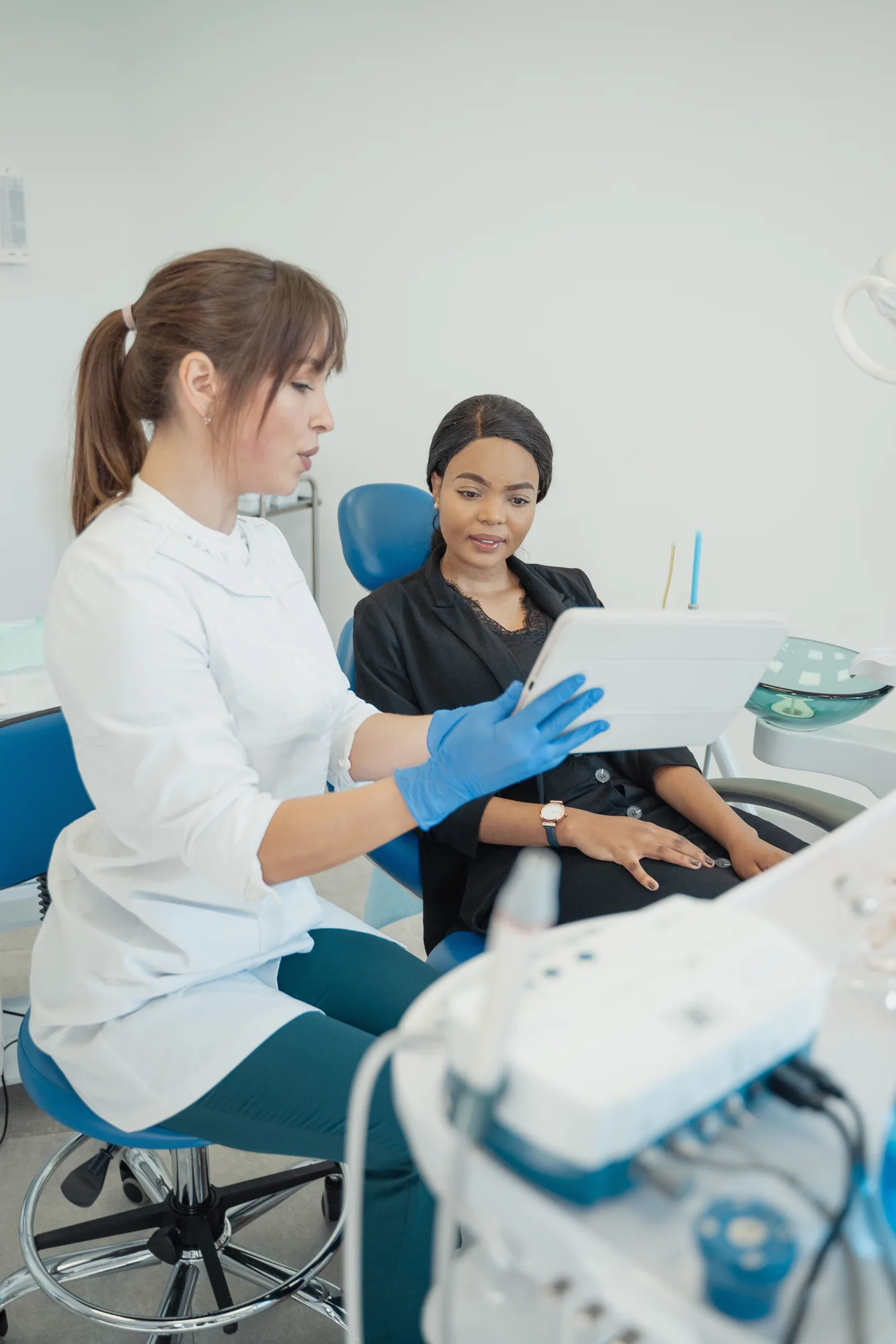 A dentist and a patient looking at a tablet in a dental clinic