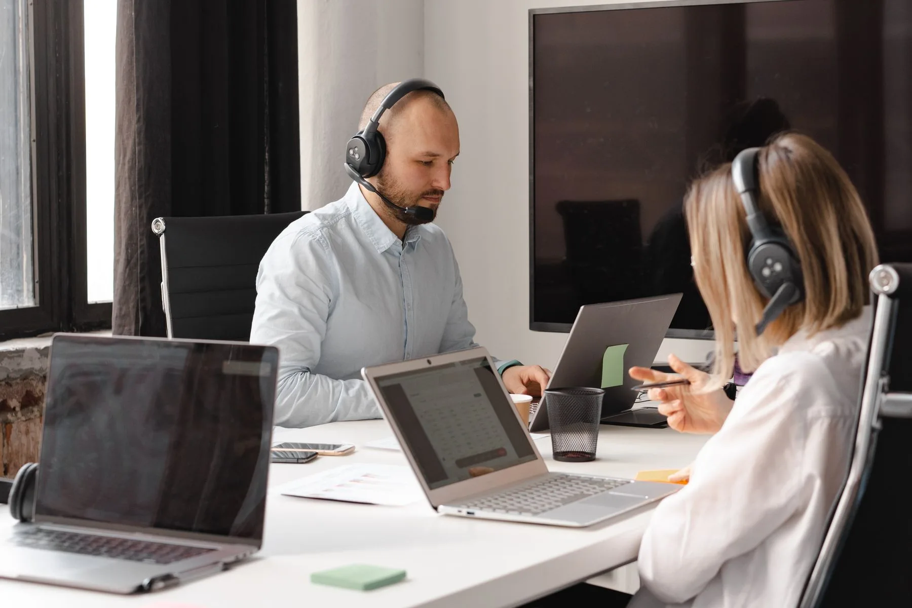 People working with headsets and laptops in an office