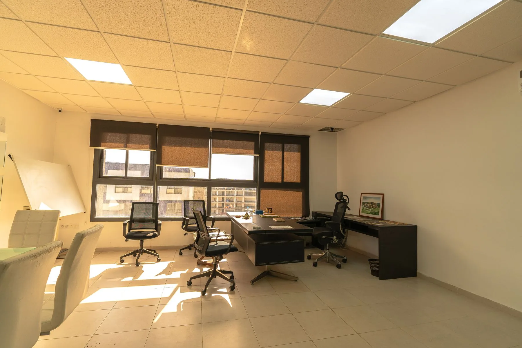 Sunlit contemporary studio with a desk and chairs.