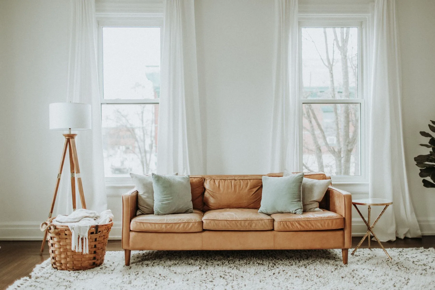 Warm leather sofa and pale curtains in a living room
