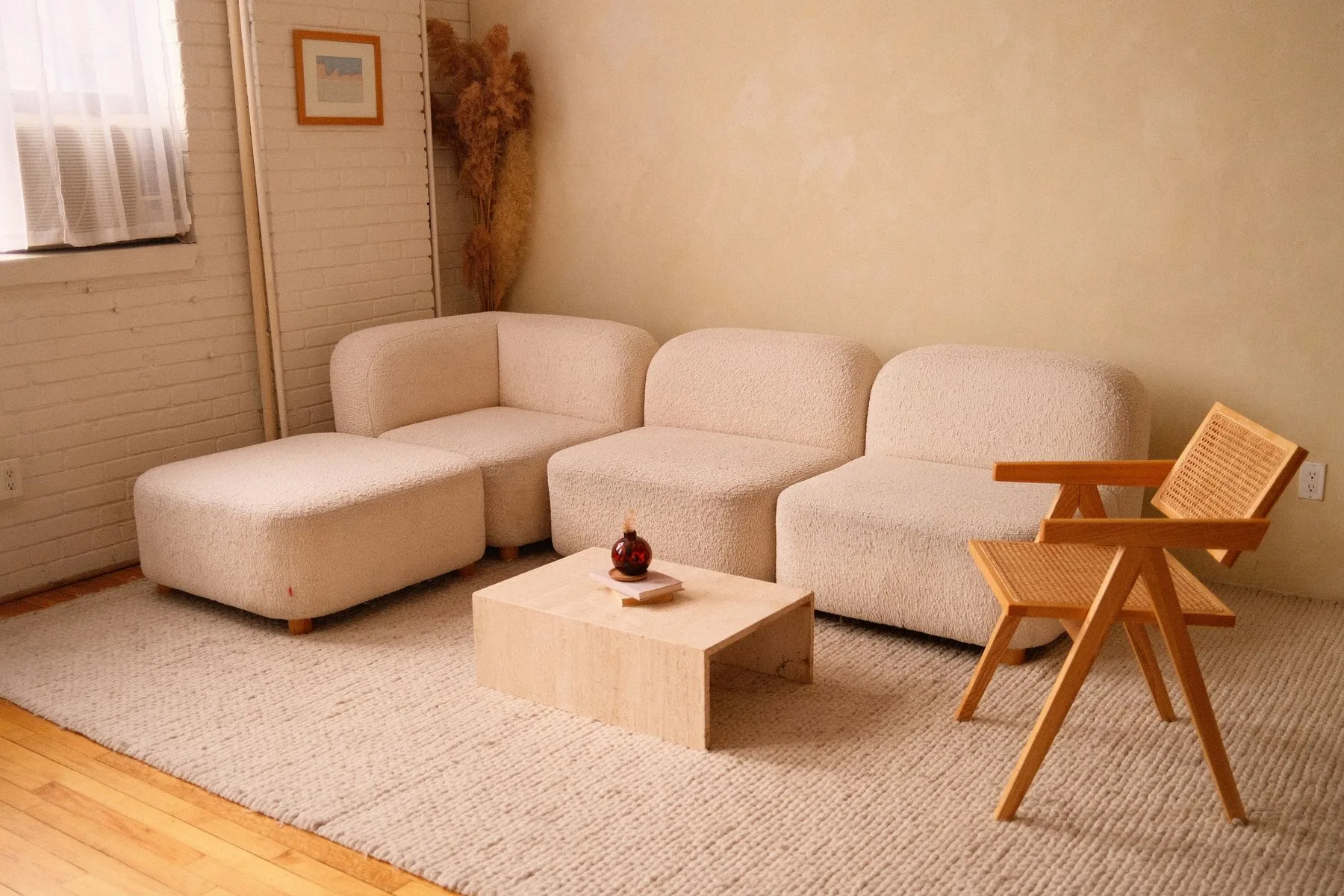 Soft light sofa and wooden chair in a sunlit living room