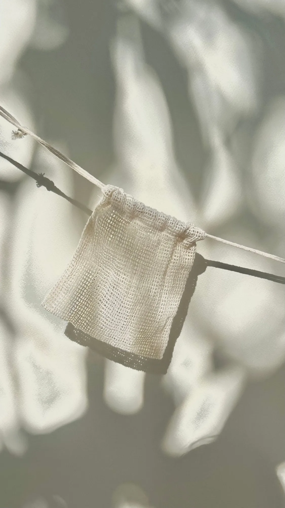 A small cotton mesh bag hanging in sunlight