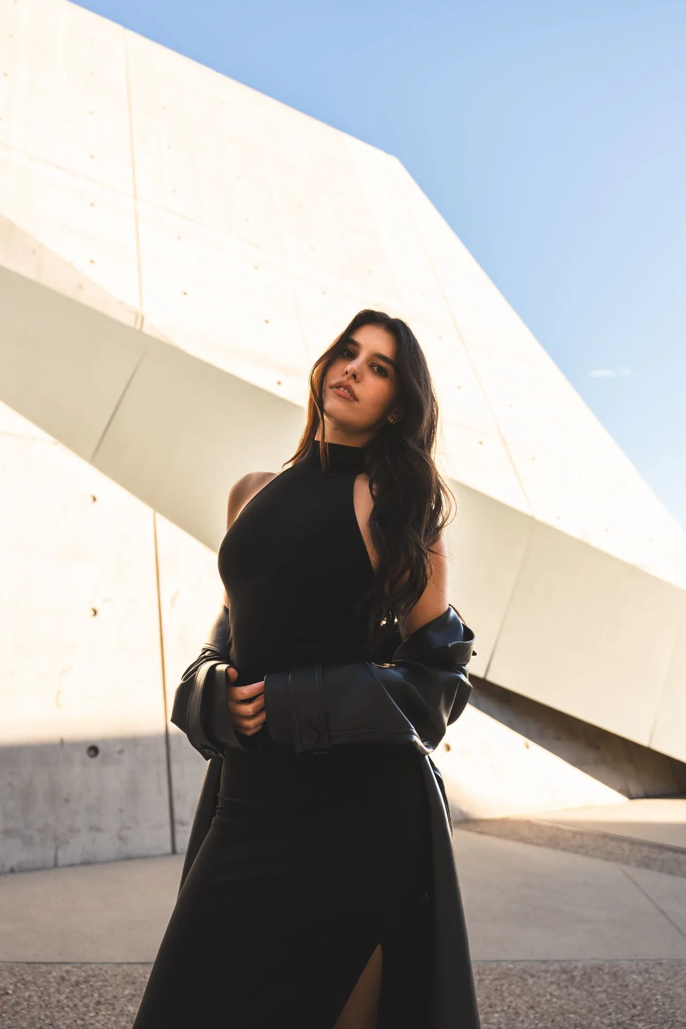 Editorial portrait beside geometric concrete architecture