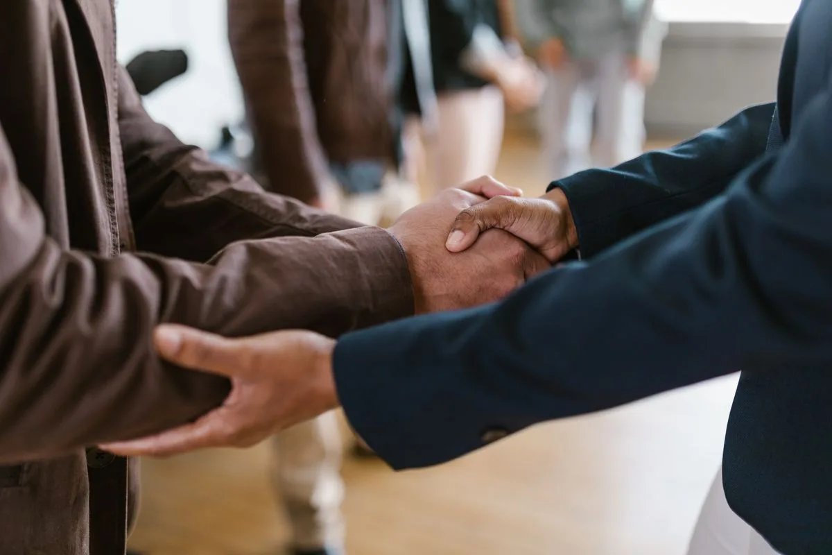 People greeting one another with a handshake