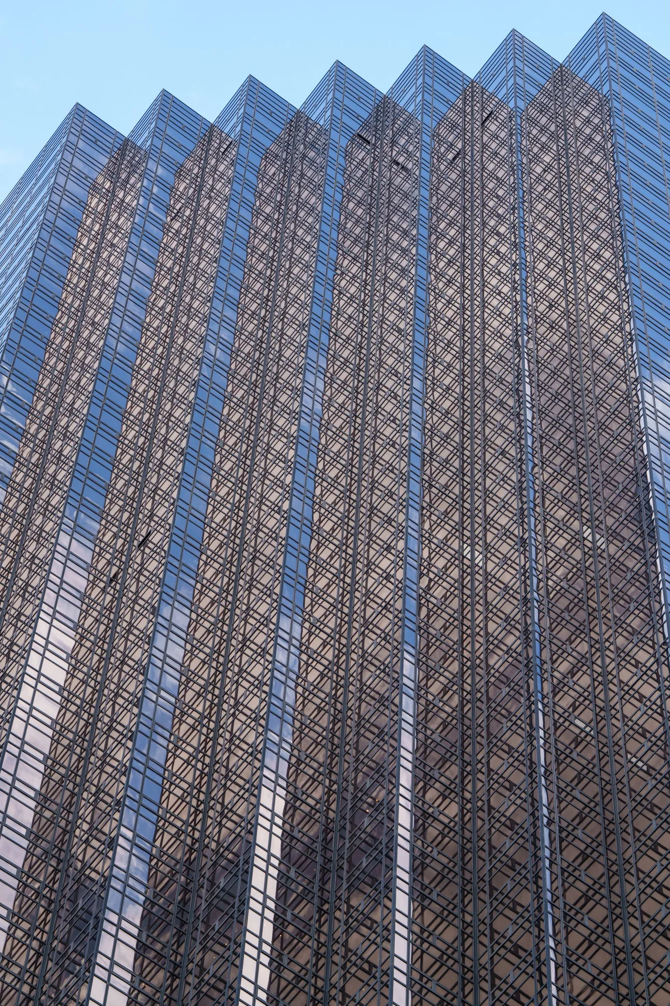Angular glass office architecture reflecting the surrounding city.