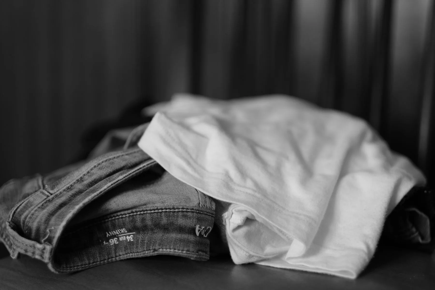 Monochrome close-up of folded jeans and a T-shirt