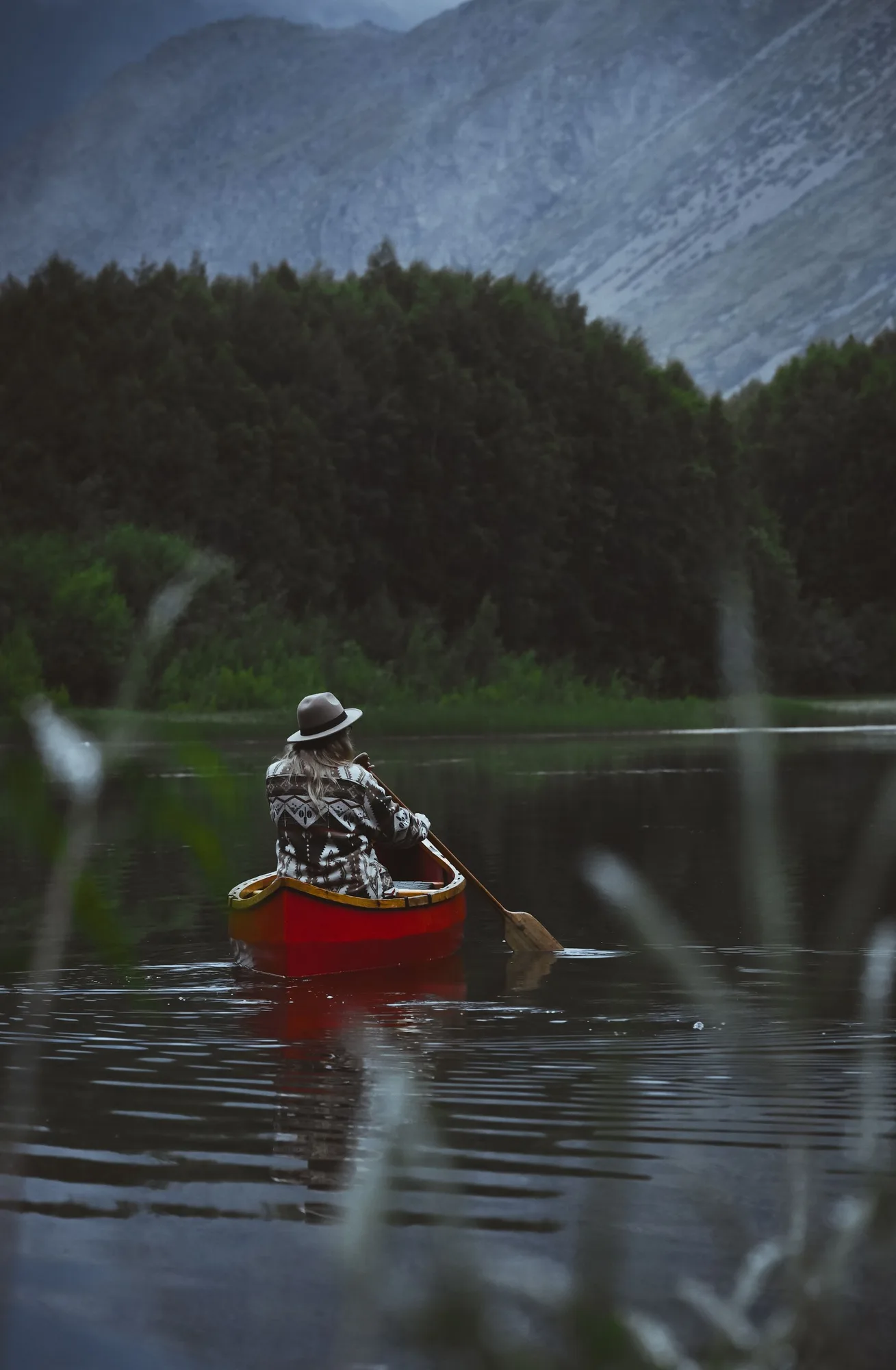 A canoe on a forested mountain lake