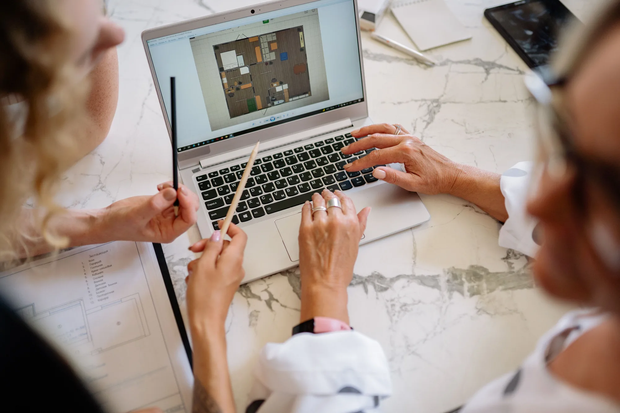 Hands reviewing a design together at a laptop