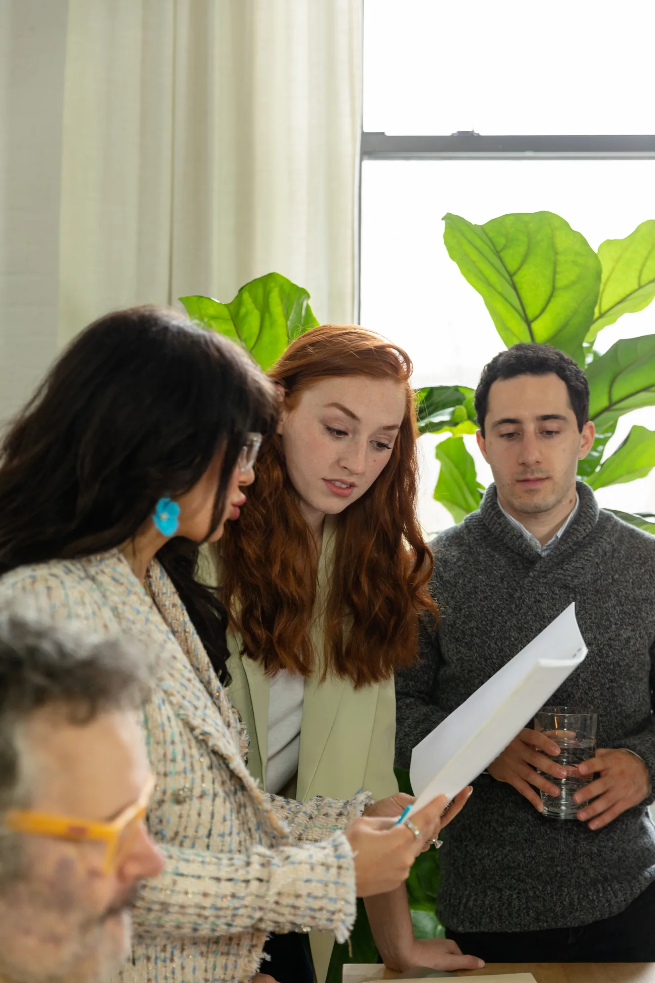 Colleagues discussing papers at a table in a bright office
