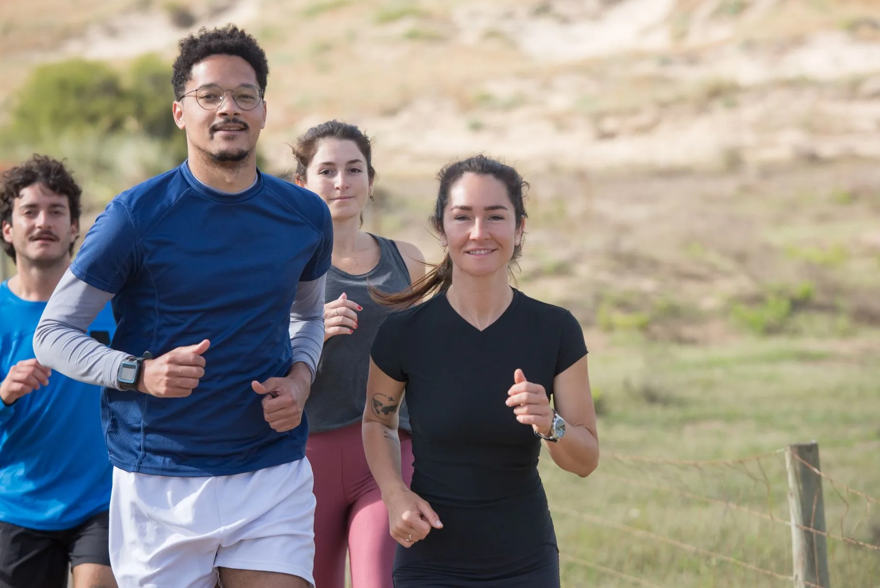 A group of adults running together on an outdoor path.