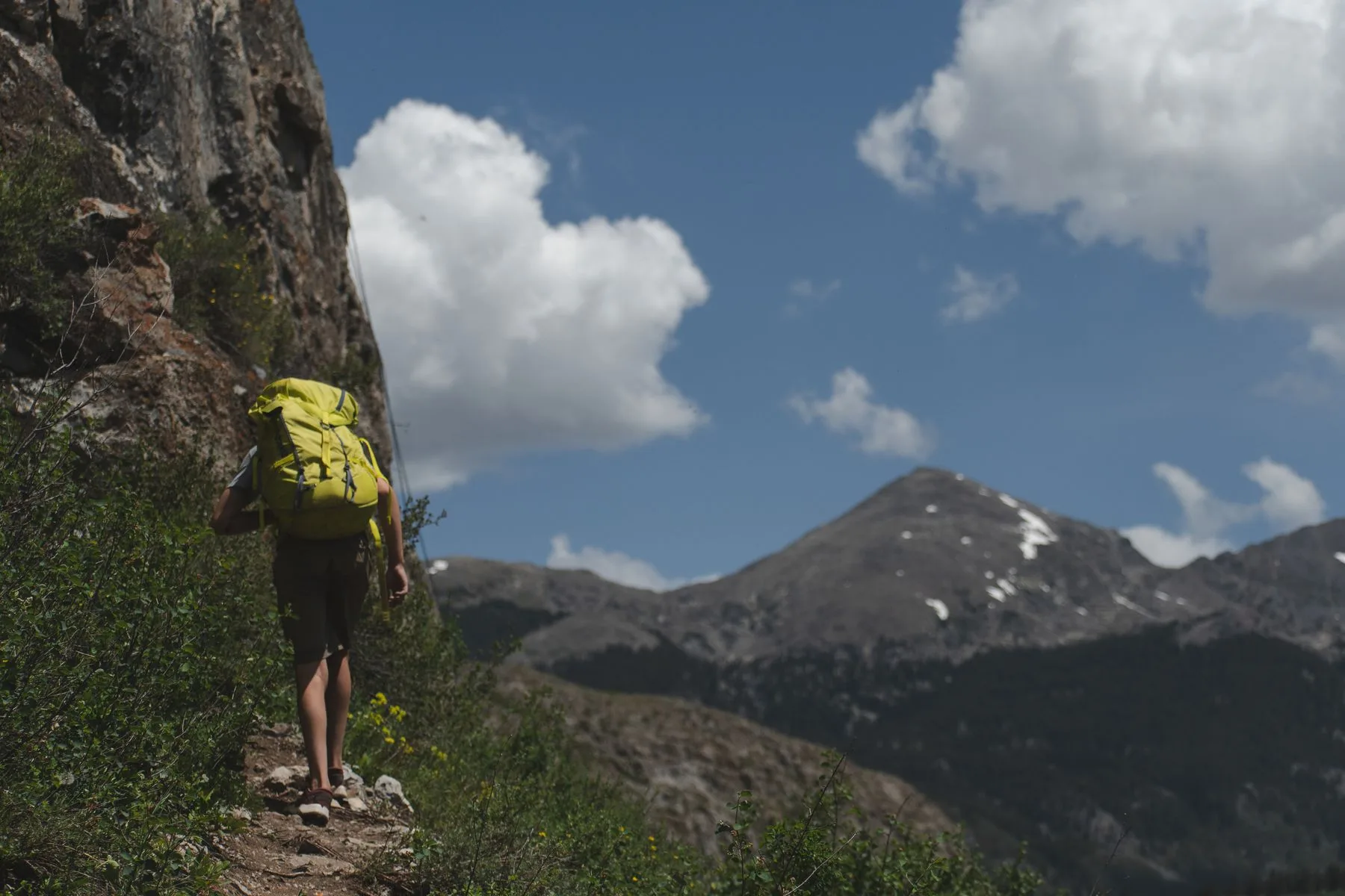 Backpacker walking through an open mountain landscape
