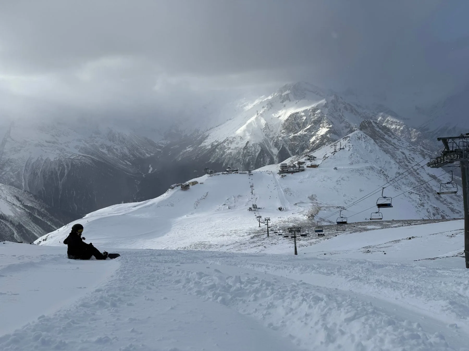 Snowboarder looking across snow-covered mountains