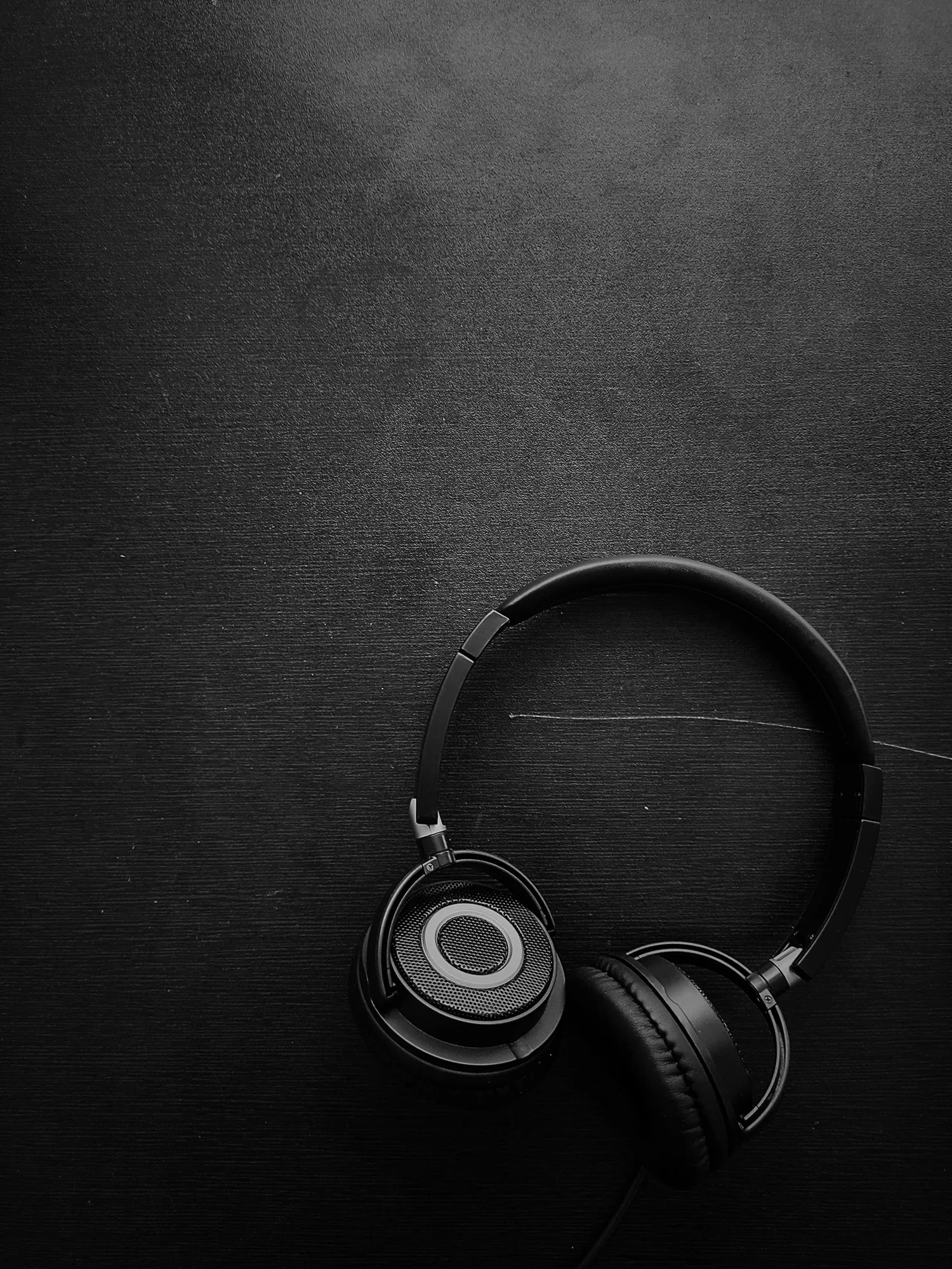 Black headphones photographed against a dark background