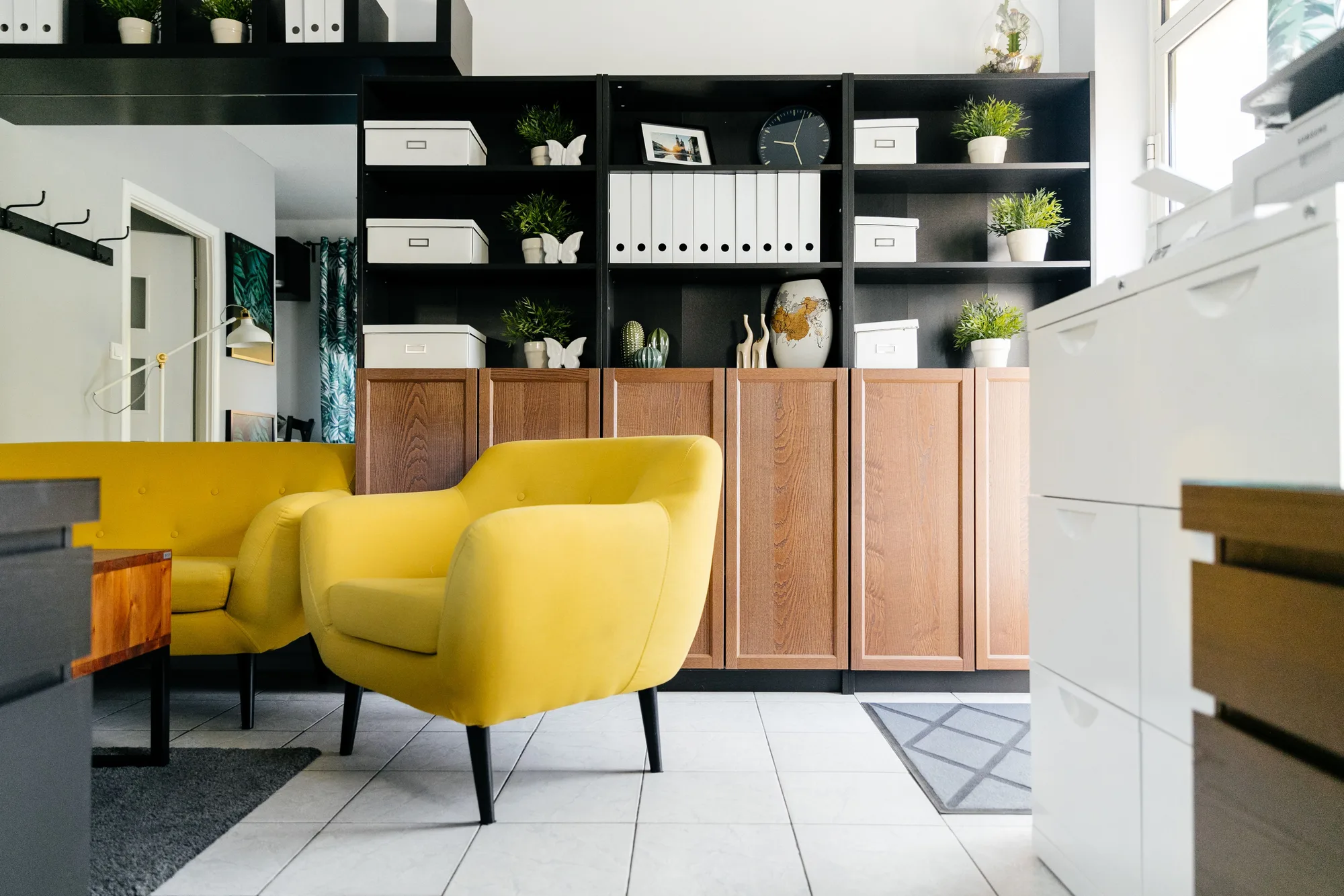A yellow armchair and wooden shelving in a bright living room