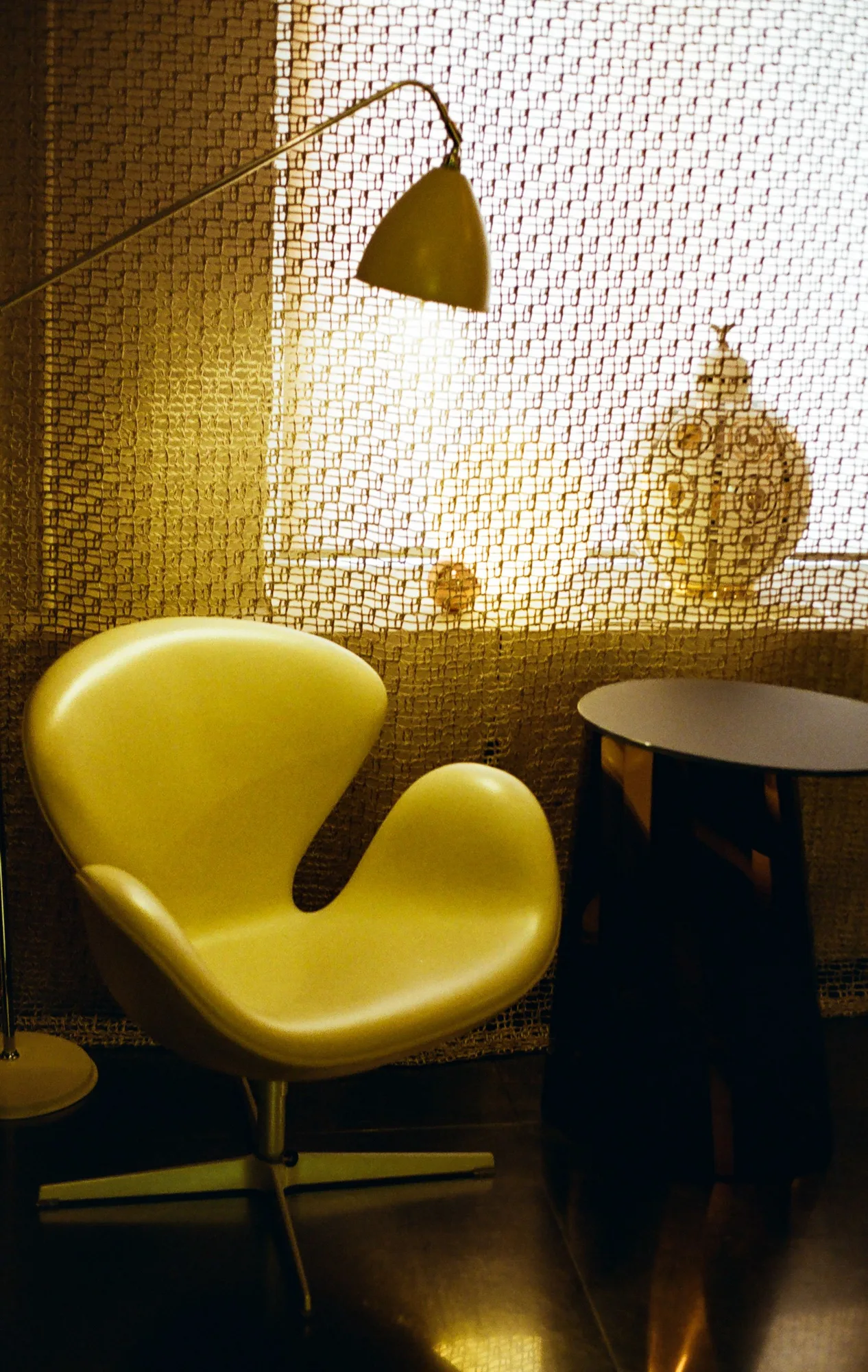 A sculptural yellow chair beside a round table