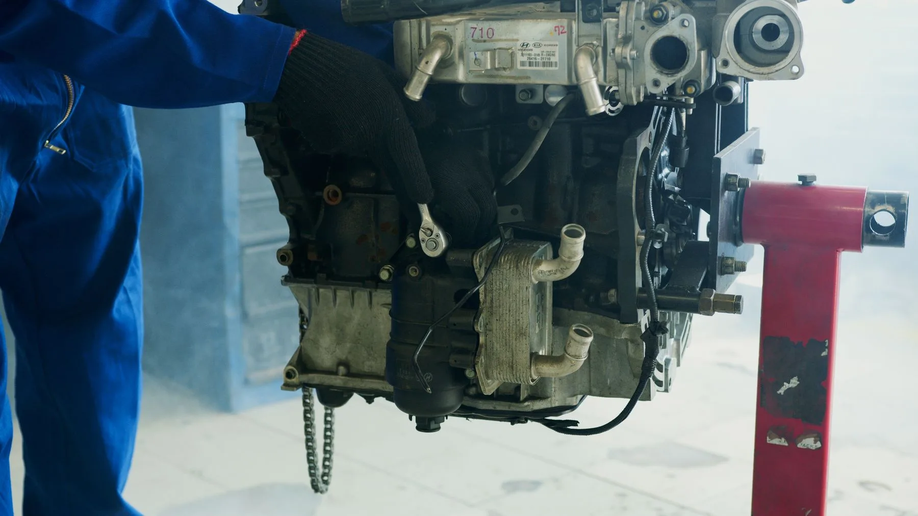 Gloved hands working on a car engine