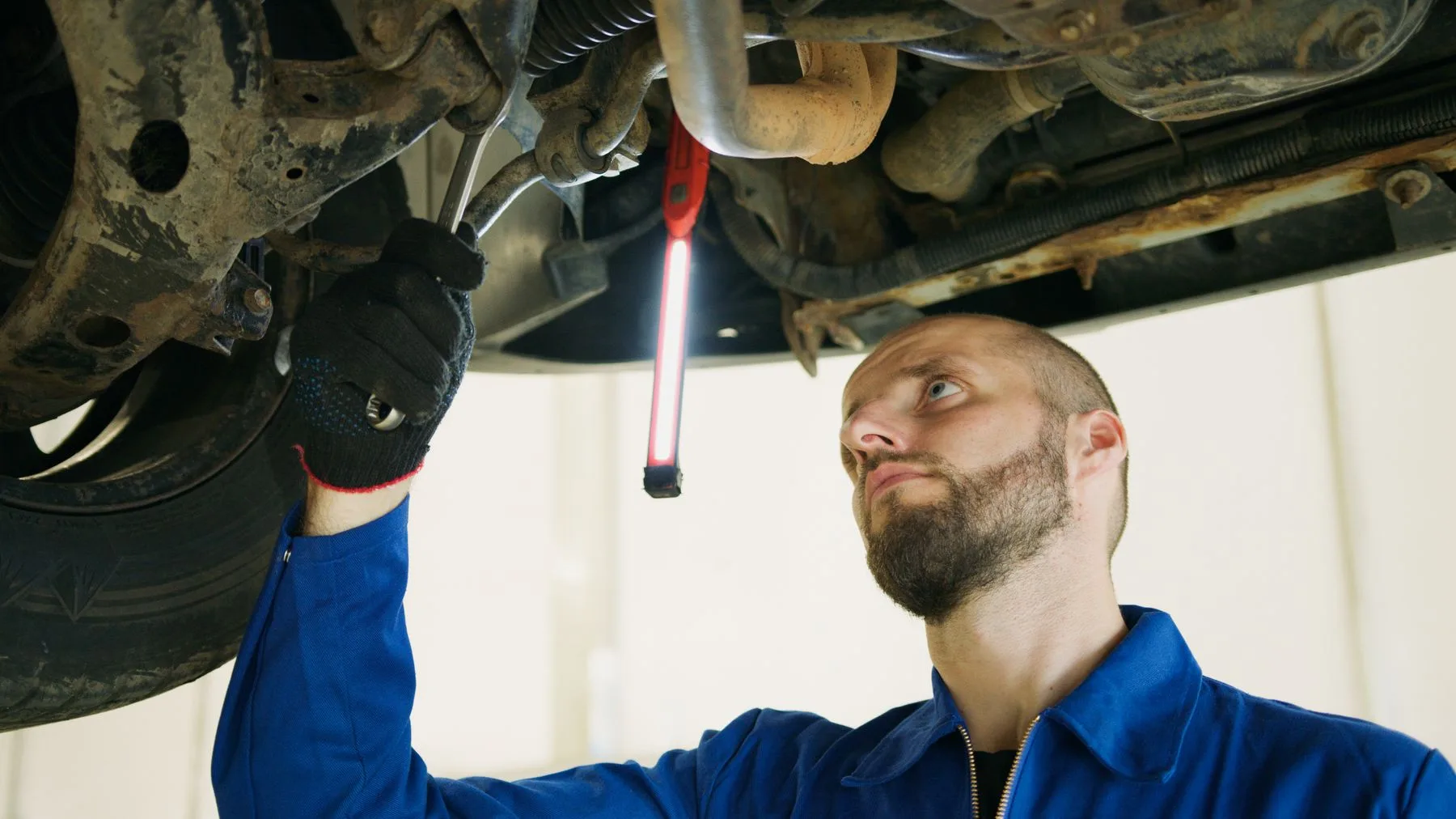 Mechanic working beneath a car on a workshop lift