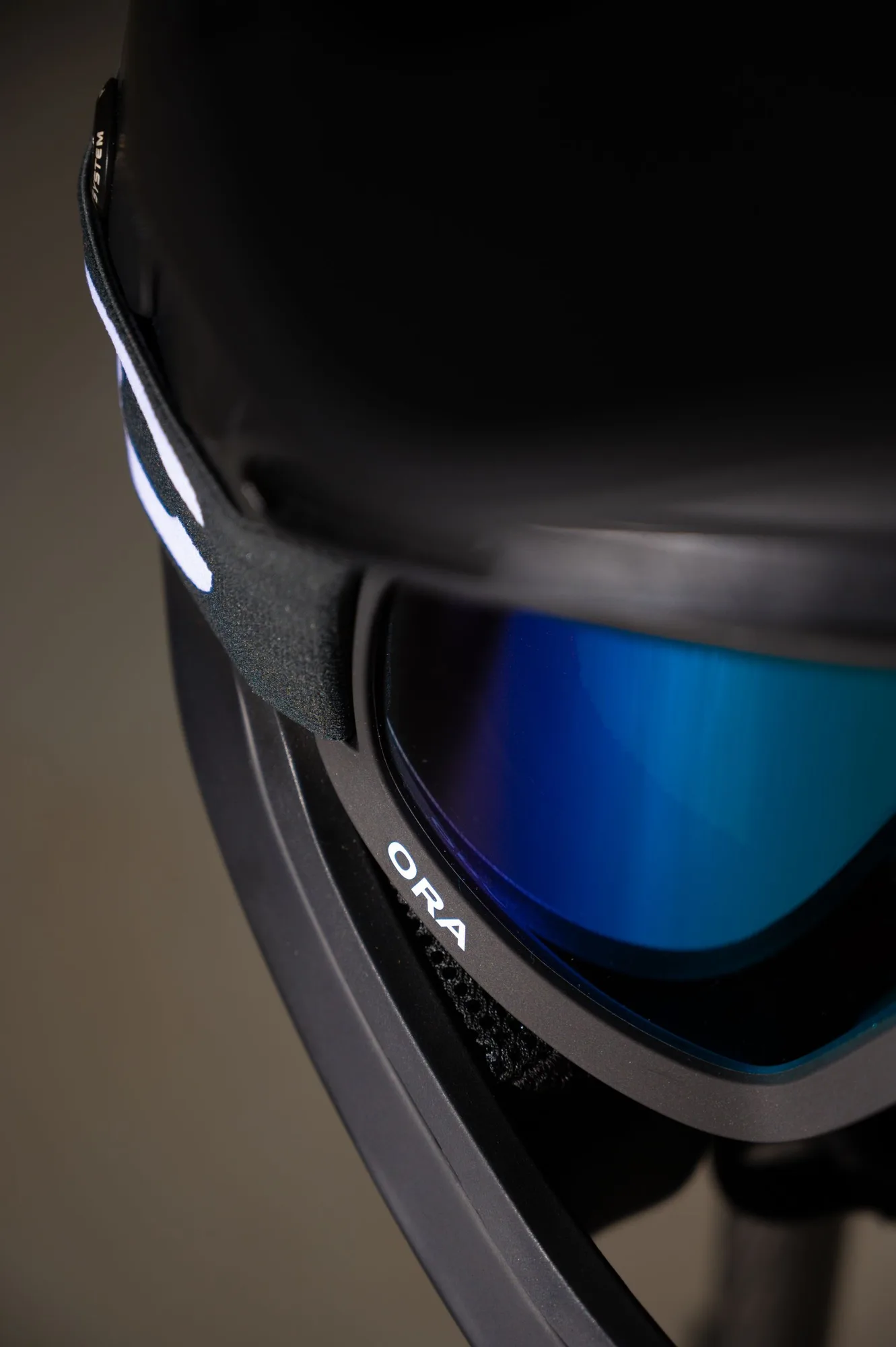 Black cycling helmet and blue goggles photographed close up